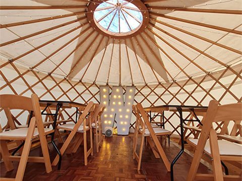 Yurt Interior with table chairs and a W back drop